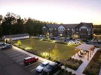A parking lot with cars and a building in the background.